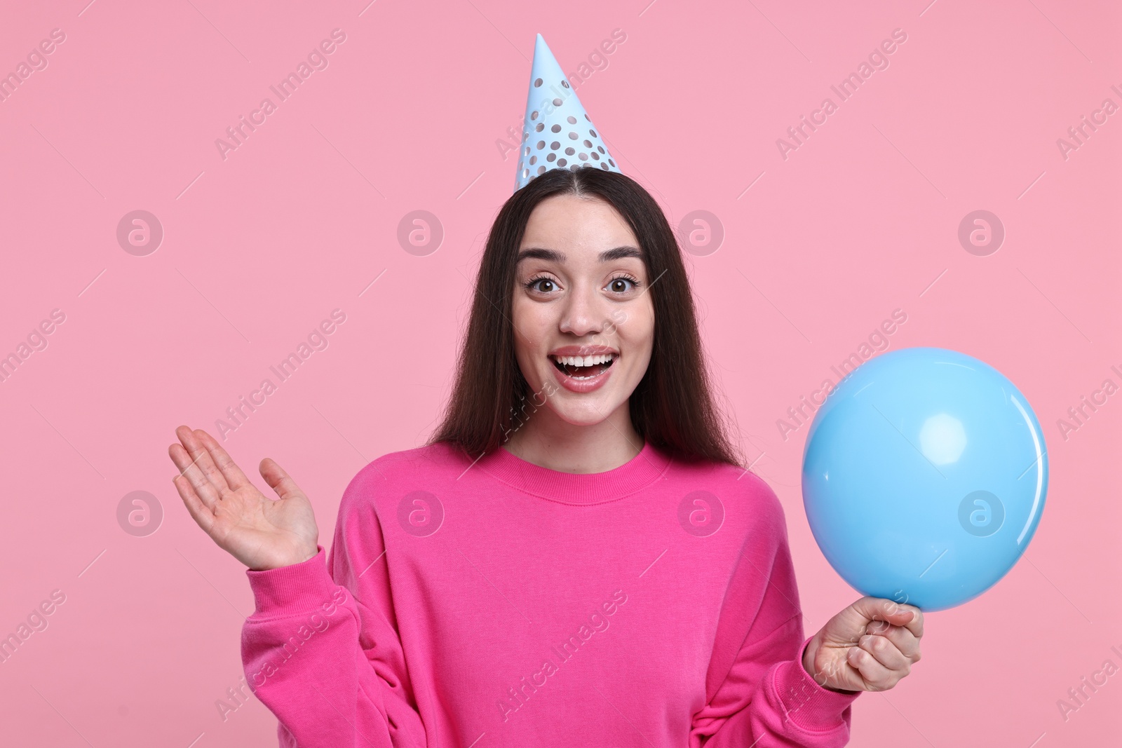 Photo of Happy woman in party hat with balloon on pink background