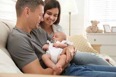 Photo of Happy couple holding their sleeping baby at home