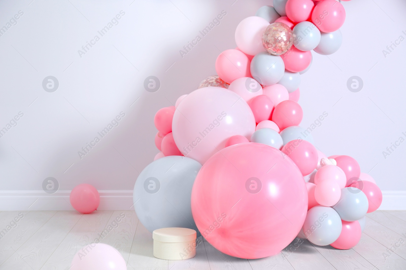 Photo of Beautiful composition with balloons near light wall