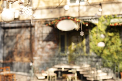 Blurred view of building with green vine on sunny day