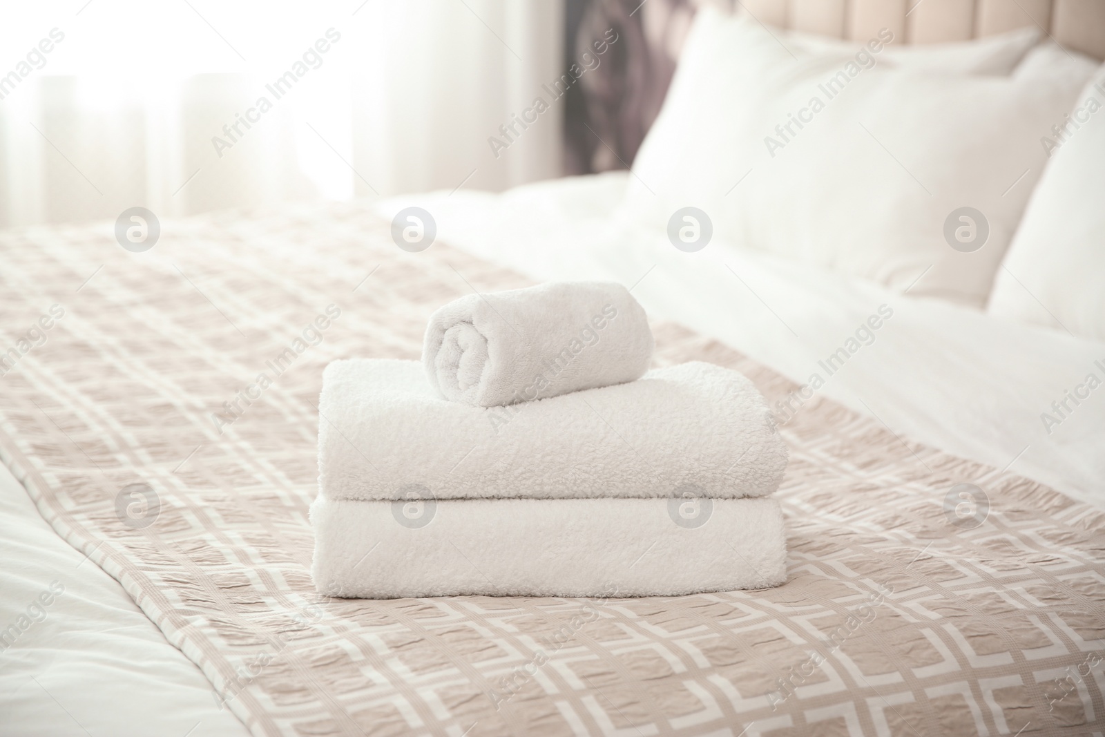 Photo of Clean white towels on bed at home