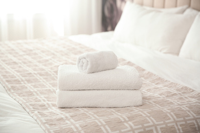 Clean white towels on bed at home