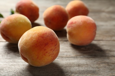 Photo of Fresh sweet peaches on wooden table, closeup