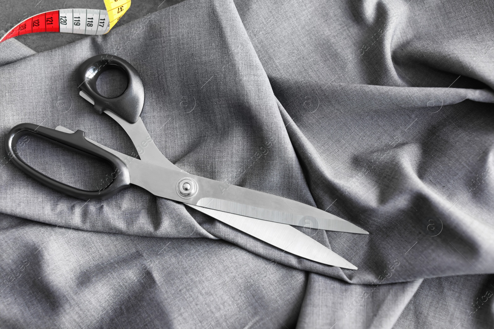 Photo of Scissors and measuring tape for tailoring on fabric