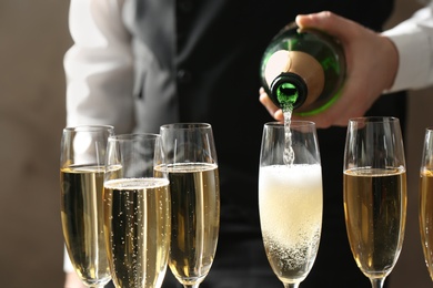 Photo of Waiter pouring champagne into glass, closeup view