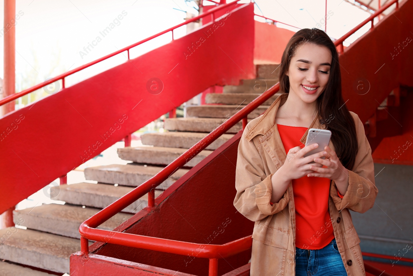 Photo of Young woman using mobile phone outdoors