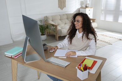 Photo of African American woman using modern computer for studying at home. Distance learning
