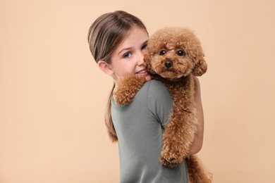 Photo of Little child with cute puppy on beige background. Lovely pet