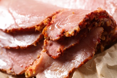 Photo of Slices of delicious cooked ham on parchment, closeup