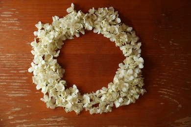 Photo of Frame made of beautiful white jasmine flowers on wooden table, flat lay. Space for text