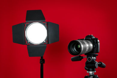 Professional video camera and lighting equipment on red background