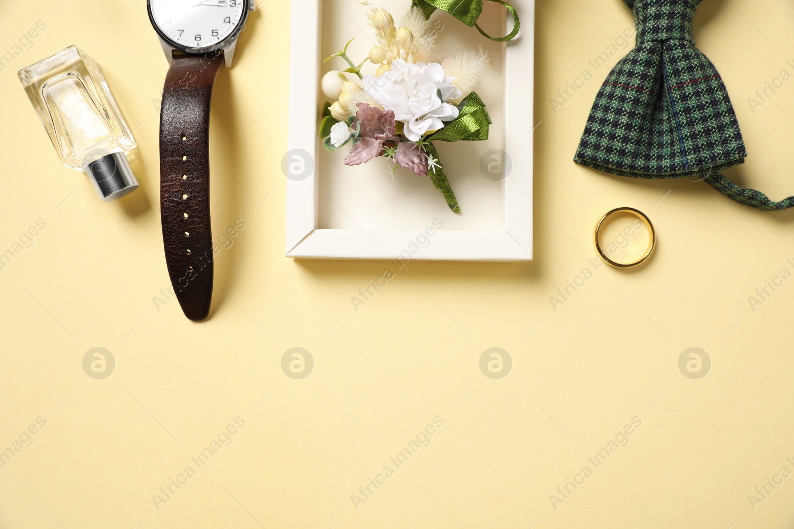 Photo of Wedding stuff. Flat lay composition with stylish boutonniere on yellow background, space for text
