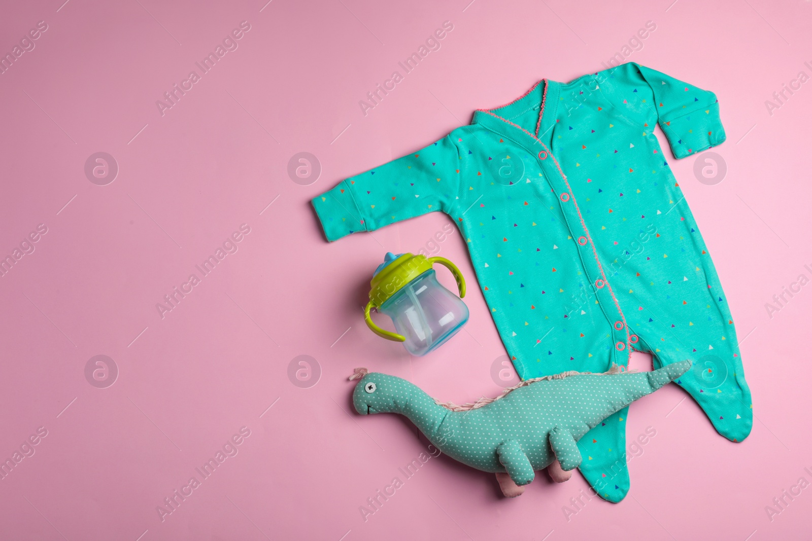 Photo of Flat lay composition with bodysuit and space for text on color background. Baby accessories