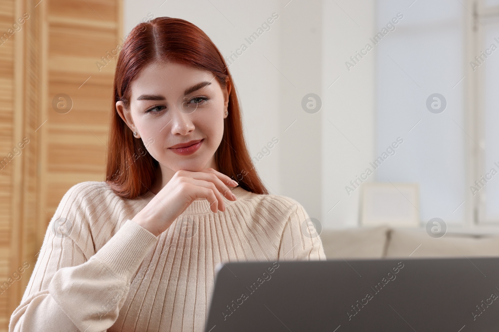 Photo of Beautiful woman using laptop in living room