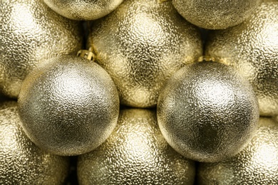 Photo of Beautiful shiny golden Christmas balls as background, top view