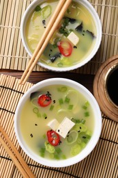 Photo of Bowls of delicious miso soup with tofu served on table, flat lay