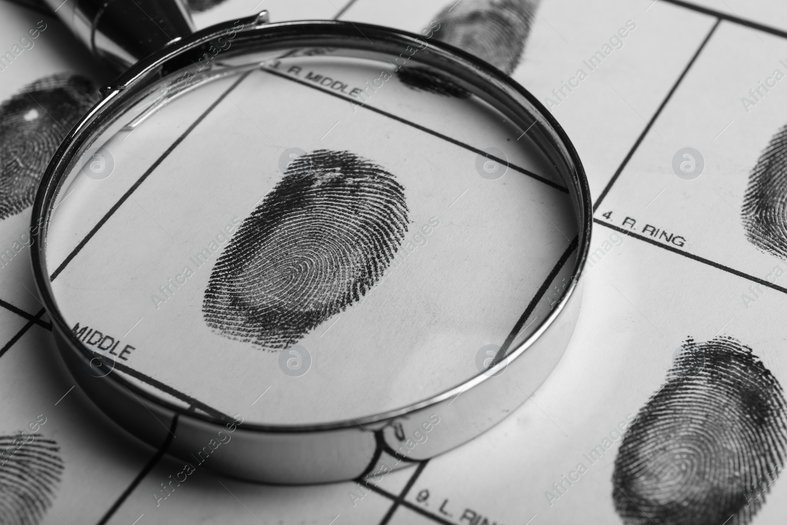 Photo of Magnifying glass and criminal fingerprint card, closeup