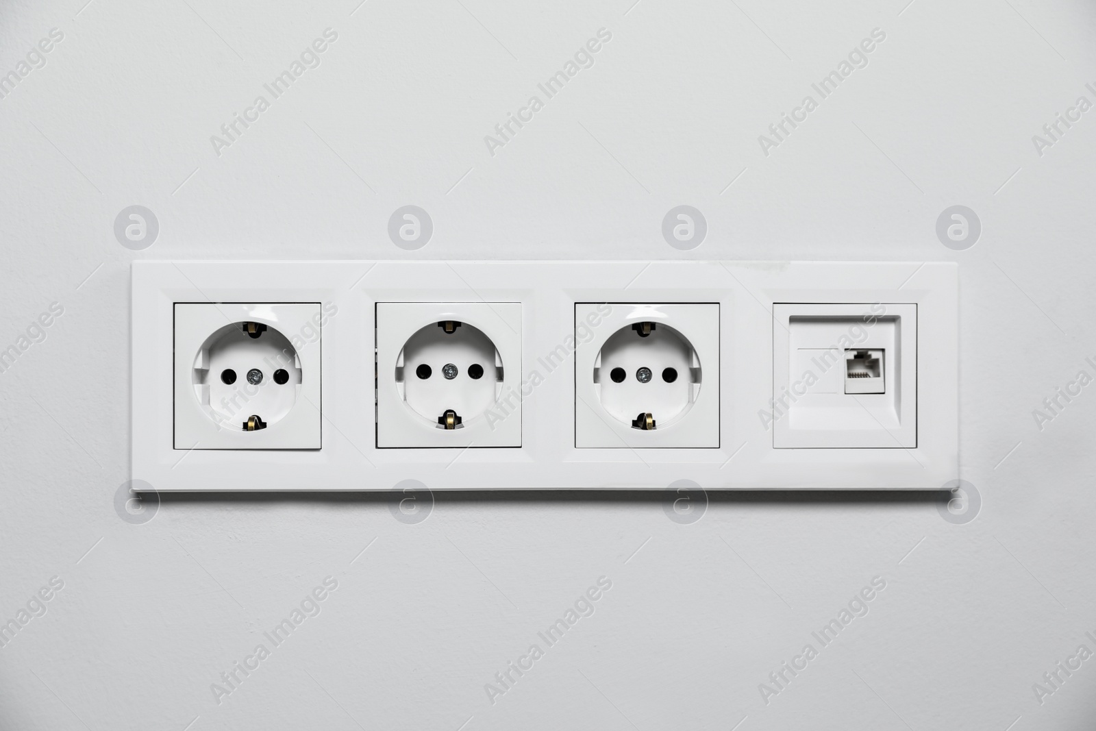 Photo of Power sockets on white wall. Electrical supply
