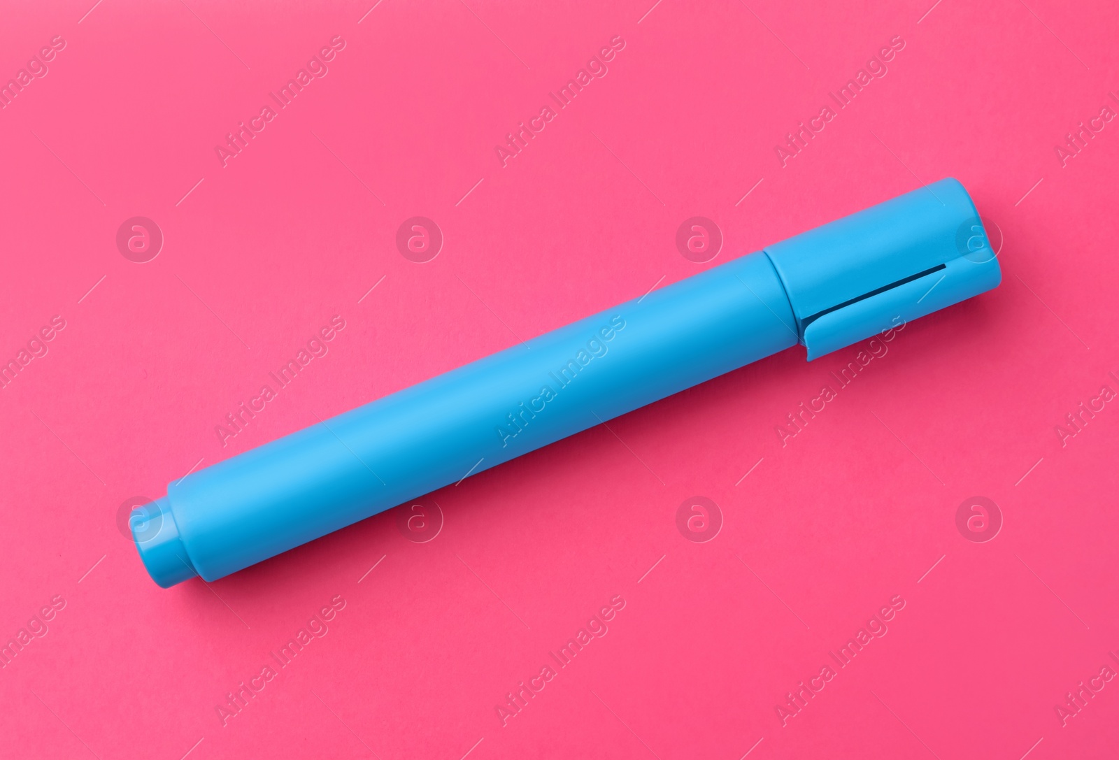 Photo of Bright light blue marker on pink background, top view