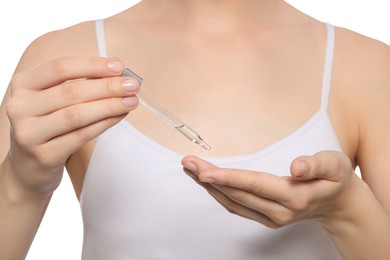 Photo of Young woman applying essential oil onto hand on white background, closeup