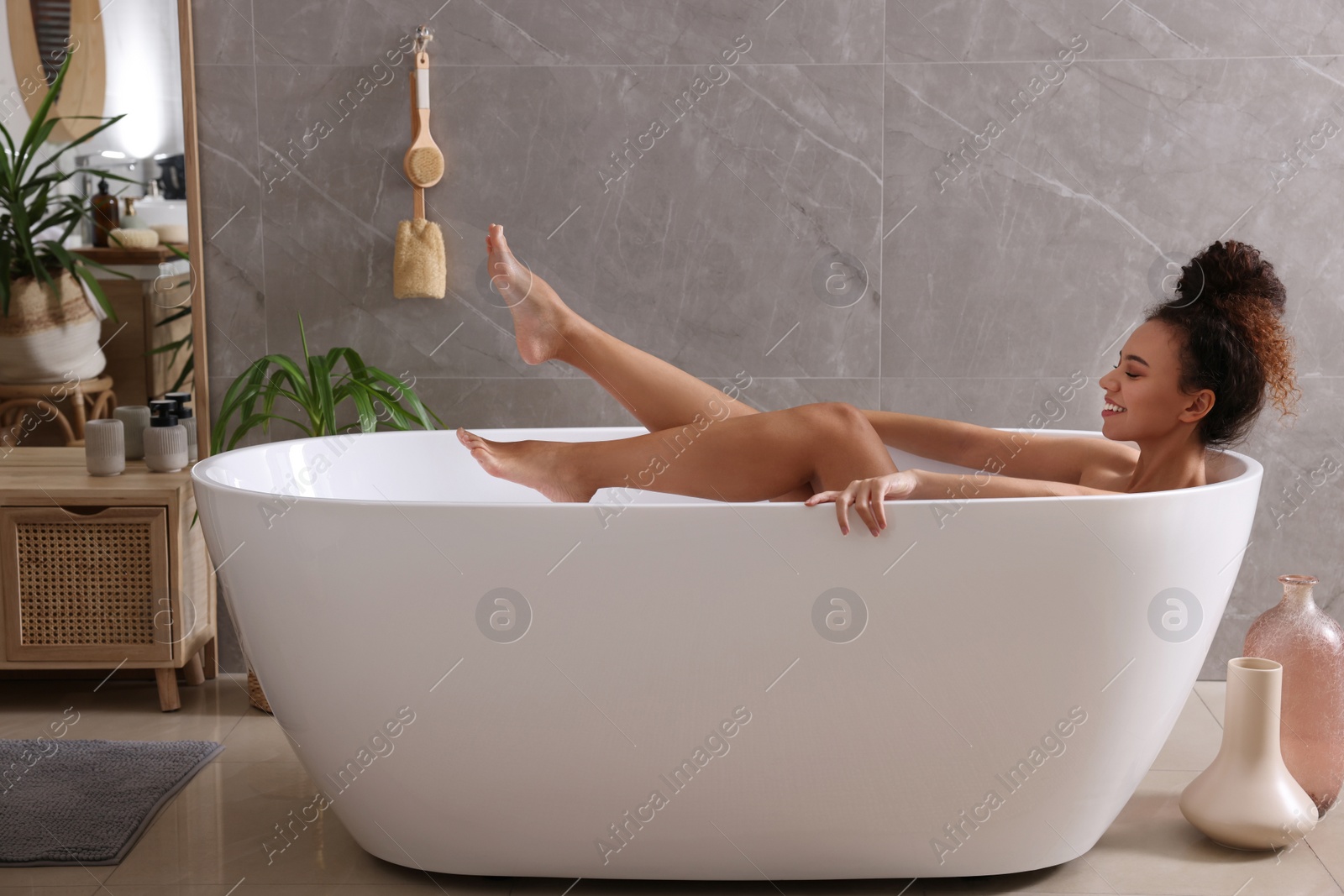 Photo of Beautiful African American woman taking bath indoors