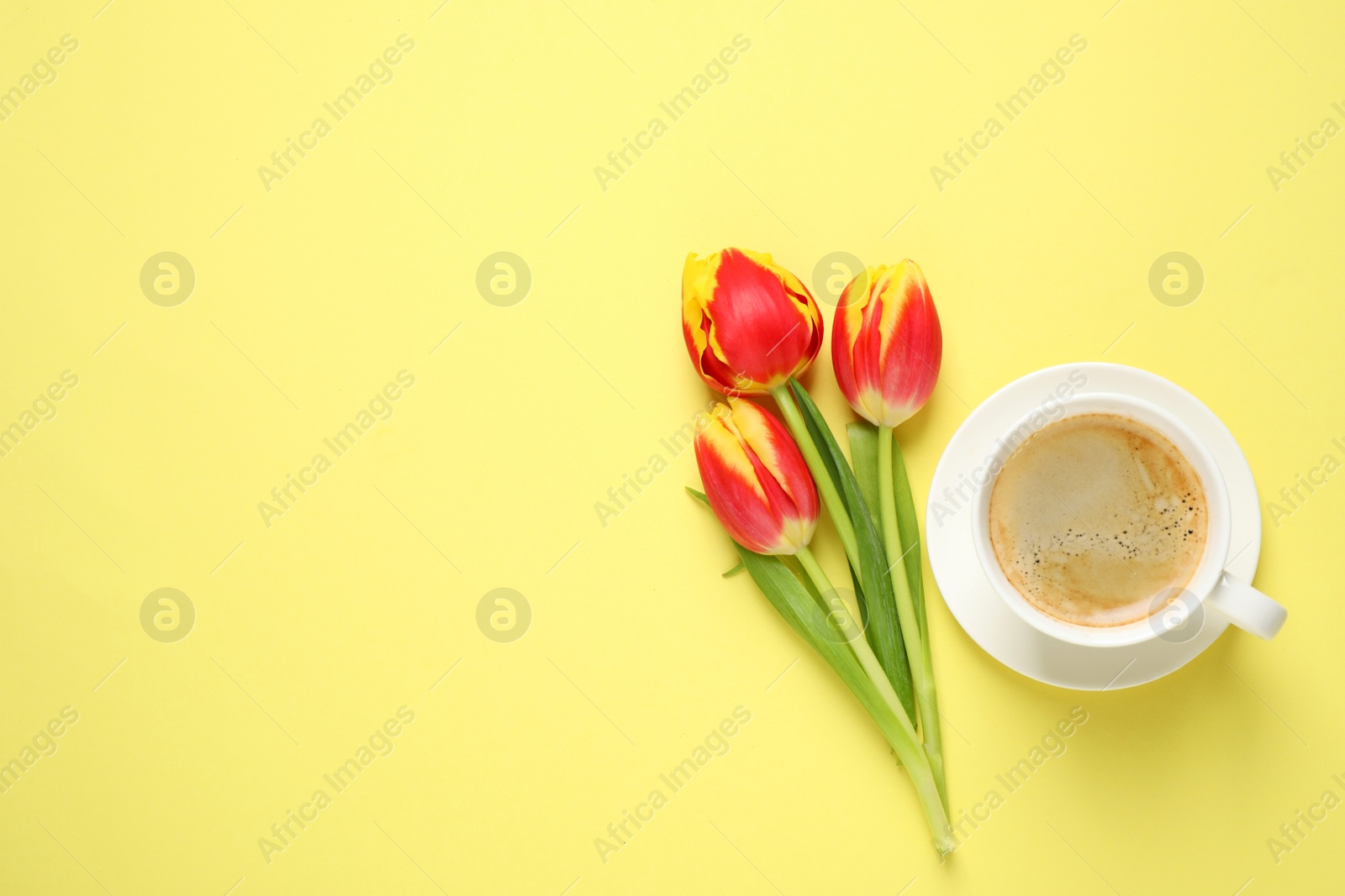 Photo of Spring tulips and coffee on yellow background, flat lay with space for text. Good morning