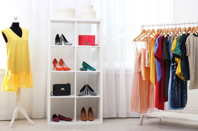 Photo of Shelving unit with shoes and purses in stylish dressing room interior