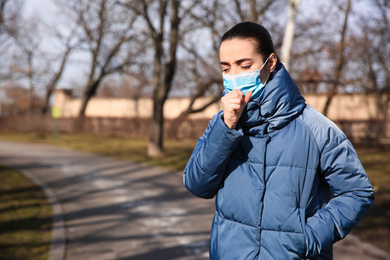 Photo of Woman wearing disposable mask outdoors. Dangerous virus