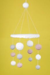 Cute baby crib mobile on yellow background