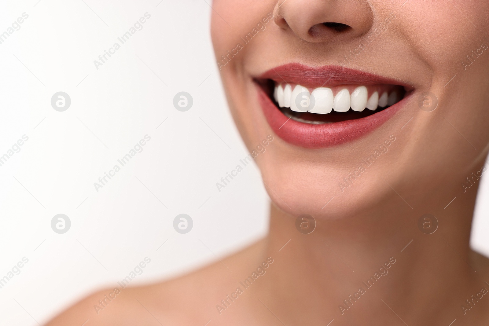 Photo of Woman with beautiful lips smiling on white background, closeup. Space for text