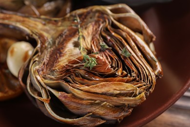 Photo of Tasty grilled artichoke on plate, closeup view