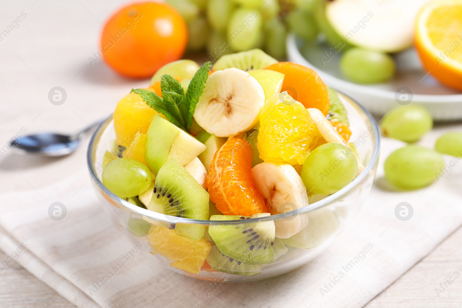 Photo of Delicious fresh fruit salad in bowl on table