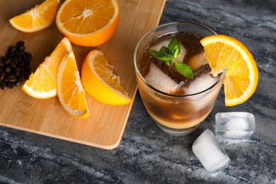 Photo of Tasty refreshing drink with coffee and orange juice on grey marble table