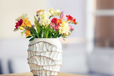 Photo of Beautiful bouquet of freesia flowers on blurred background