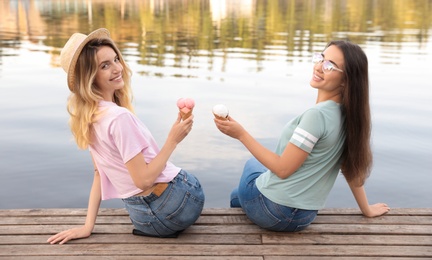 Photo of Young women with ice cream spending time together outdoors