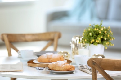 Photo of Tasty breakfast with fresh croissants on table