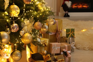 Photo of Many gift boxes under decorated Christmas tree at home