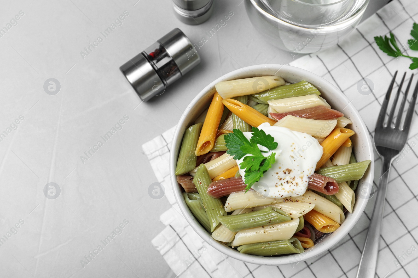 Photo of Delicious pasta with sour cream served on light grey table, flat lay. Space for text