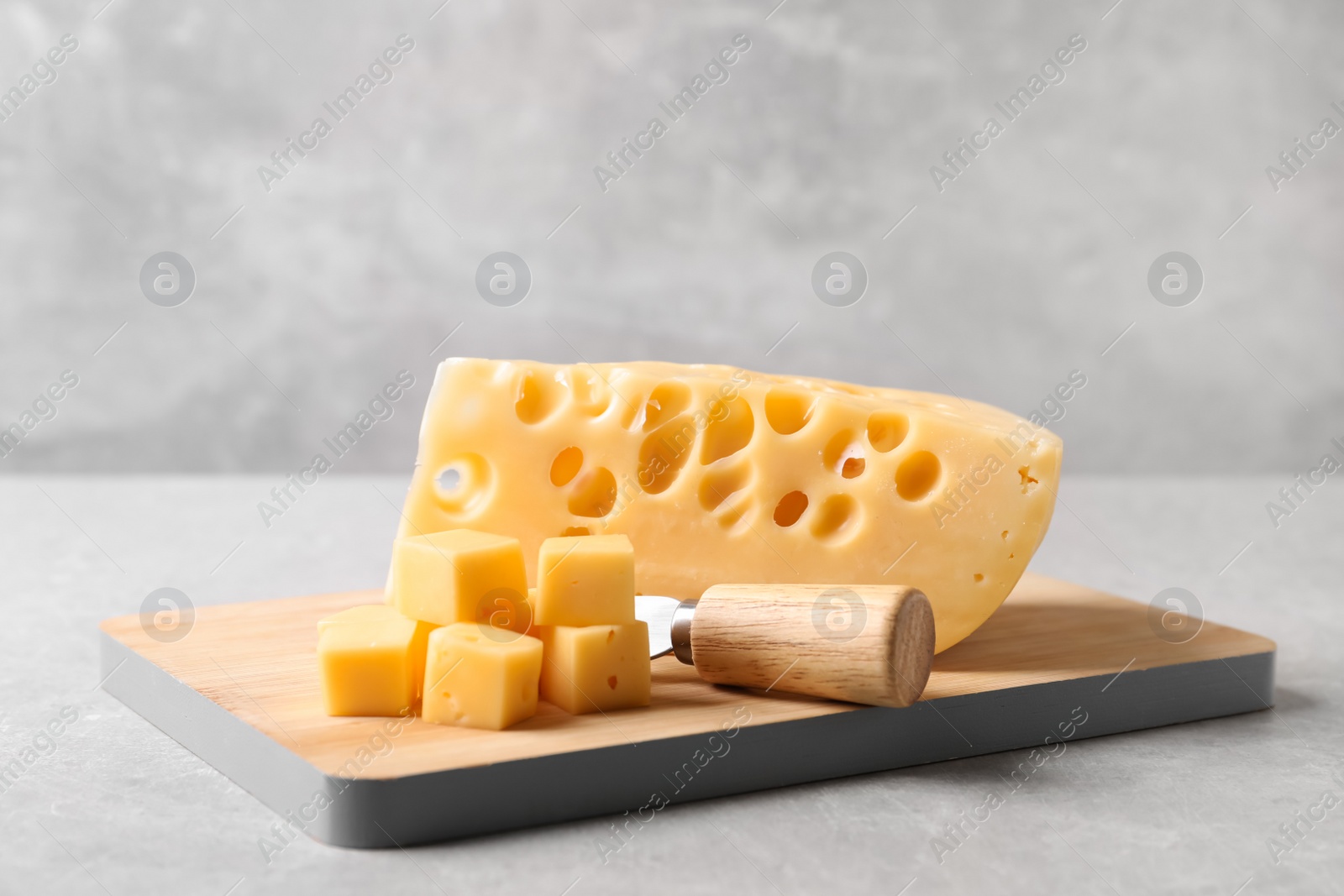 Photo of Tasty fresh cheese with fork on grey table