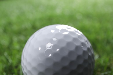 Photo of One golf ball on green background, closeup