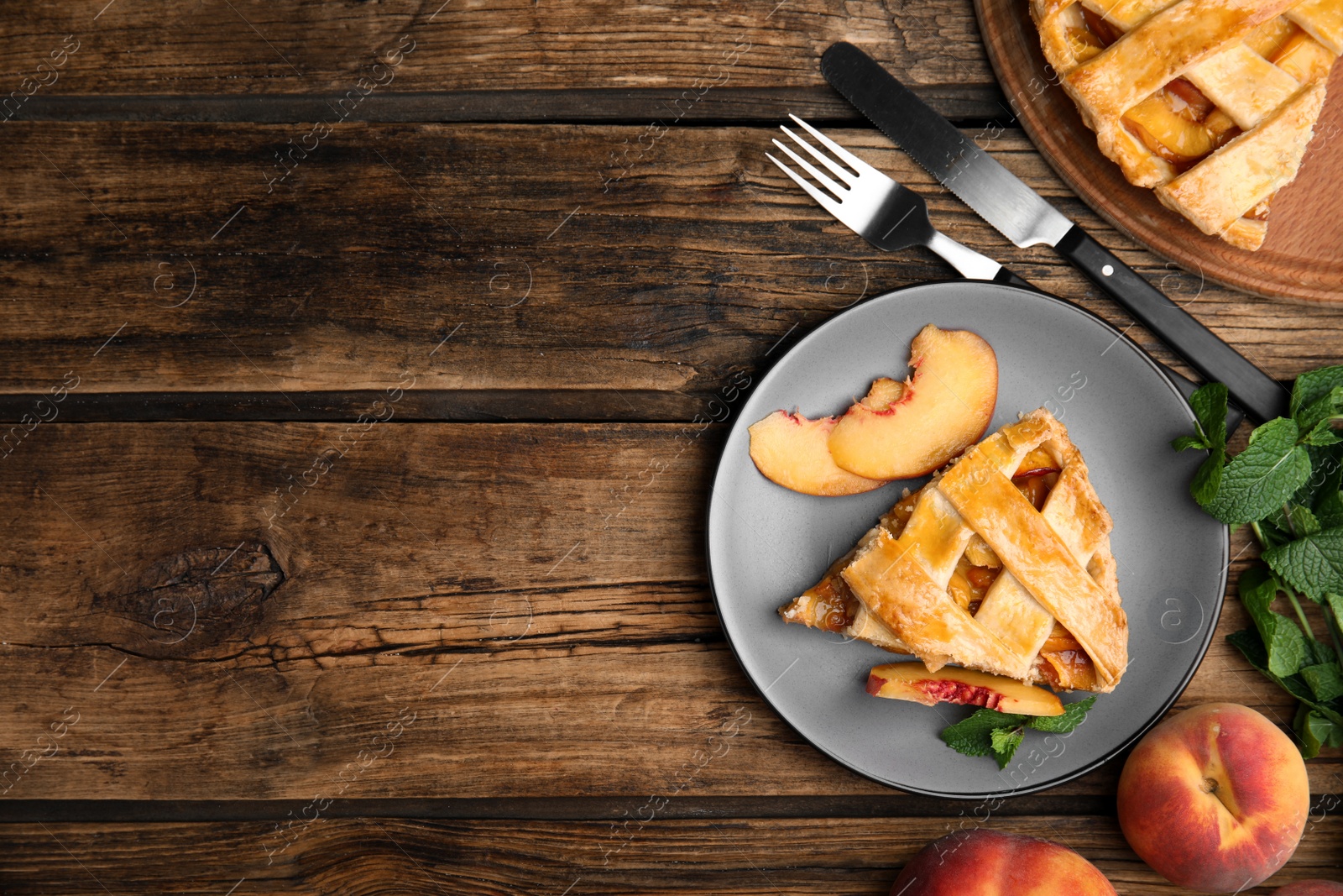 Photo of Delicious fresh peach pie served on wooden table, flat lay. Space for text