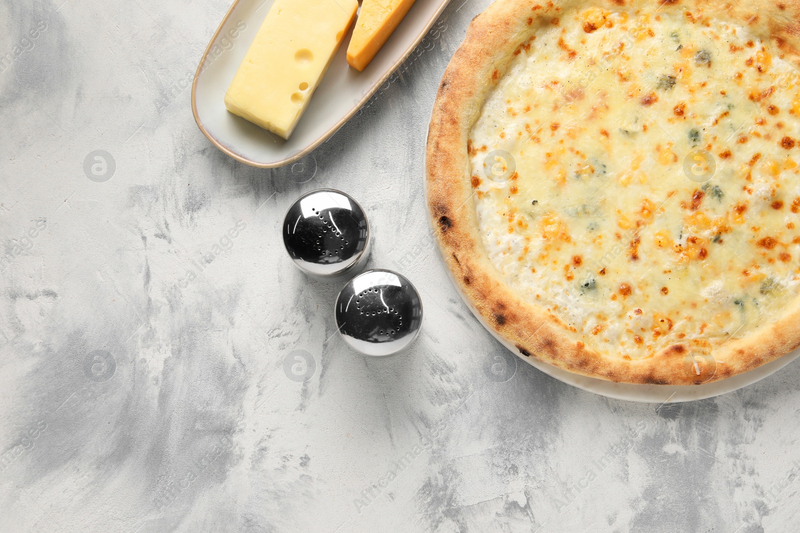 Photo of Delicious cheese pizza and different kinds of cheese on light grey textured table, flat lay. Space for text