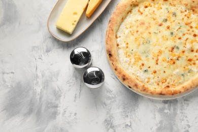 Photo of Delicious cheese pizza and different kinds of cheese on light grey textured table, flat lay. Space for text