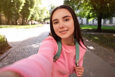 Photo of Beautiful young travel blogger takIng selfie outdoors