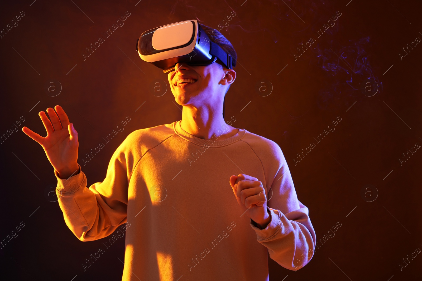 Photo of Young man with virtual reality headset on brown background