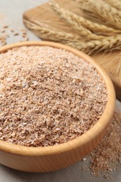 Photo of Wheat bran in bowl on table, closeup