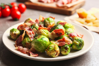 Photo of Delicious Brussels sprouts with bacon on table, closeup