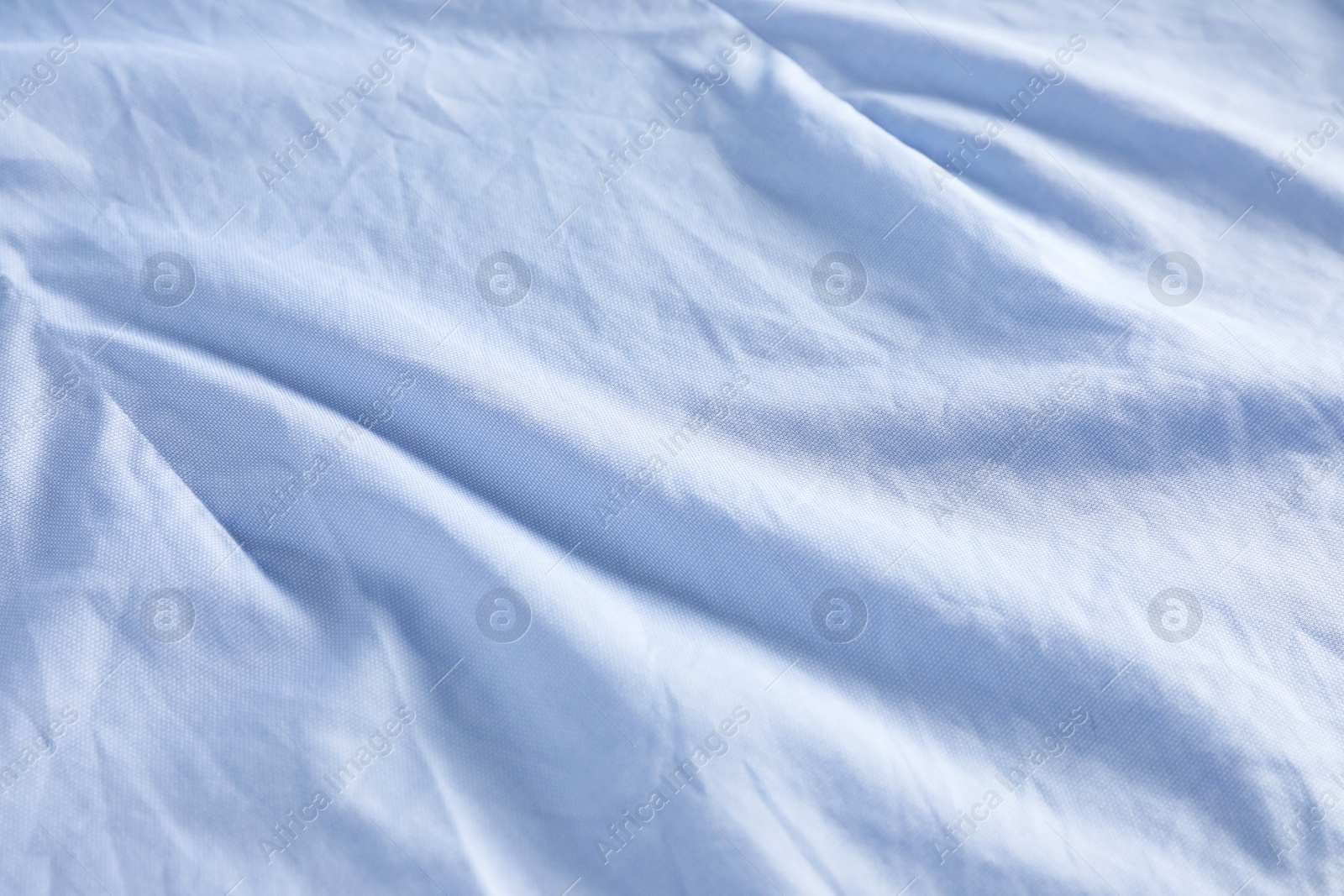 Photo of Crumpled light blue fabric as background, closeup view