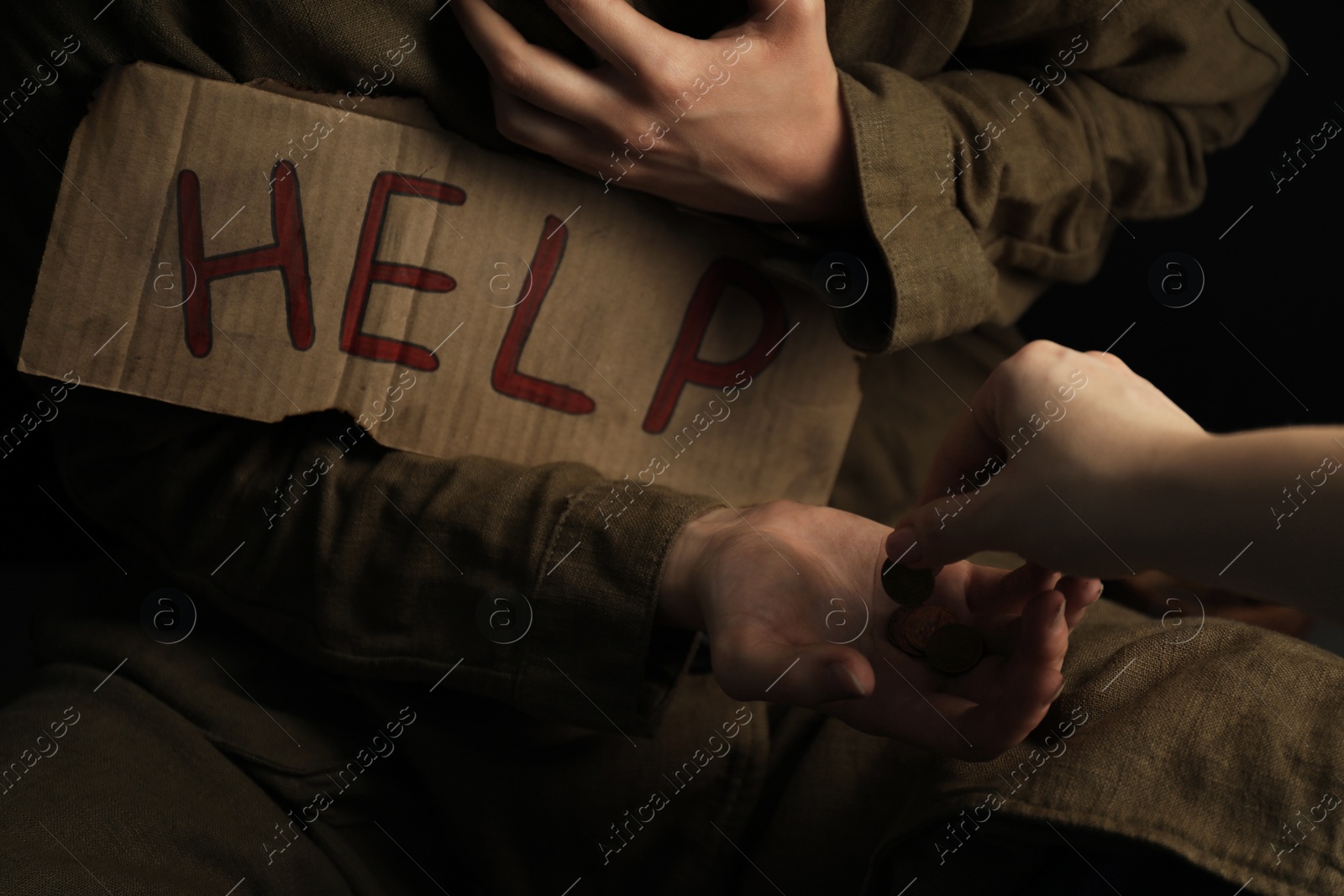 Photo of Woman giving coins to homeless with help sign, closeup. Charity and donation