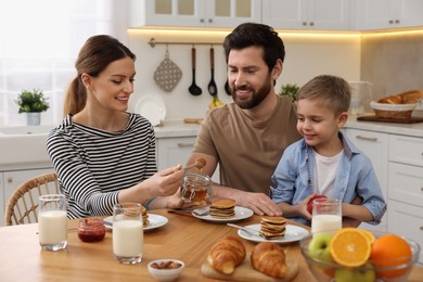 Photo of Happy family having breakfast at table in kitchen